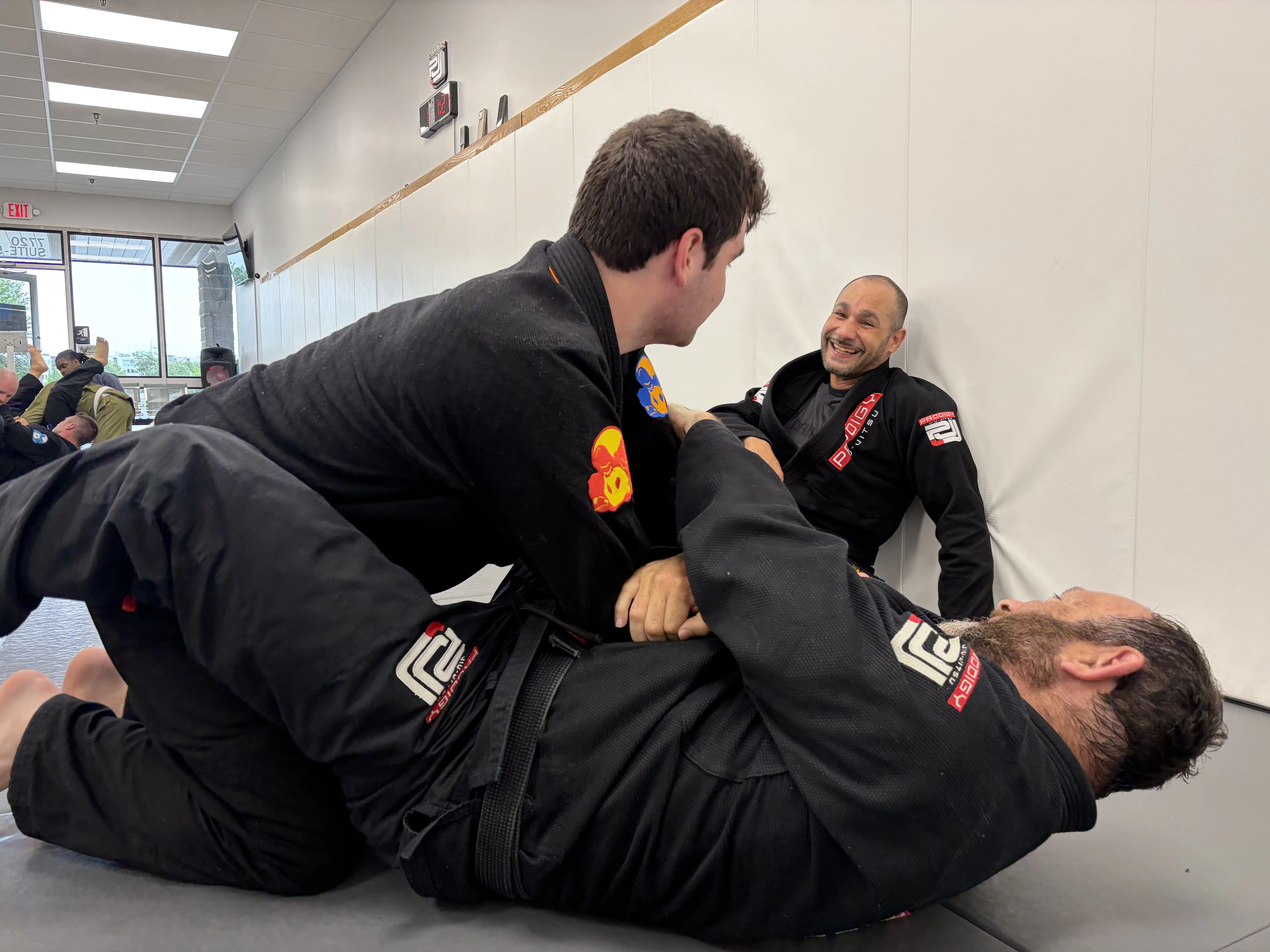 Training partners rolling while teammates watch at Prodigy Jiu-Jitsu in Fogelsville, PA